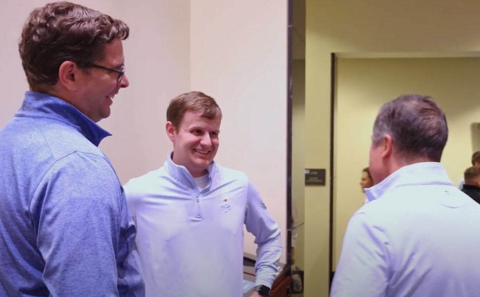 Three men standing in lobby laughing